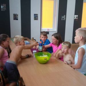 Grupa dzieci siedzących przy stole. 