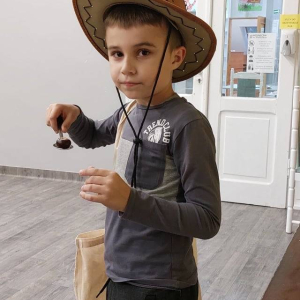 Chłopiec w kapeluszu i trzymający łyżkę. 