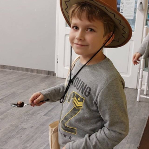 Chłopiec w kapeluszu i gitarze. 