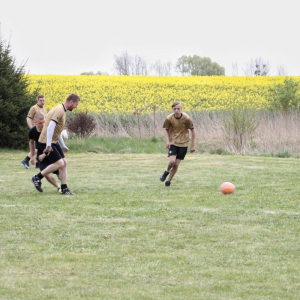 Grupa mężczyzn grających w piłkę nożną. 
