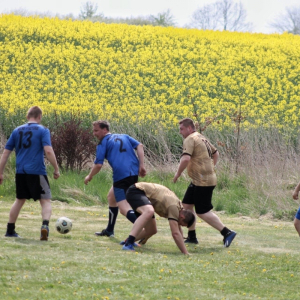 Grupa ludzi grających w piłkę nożną. 