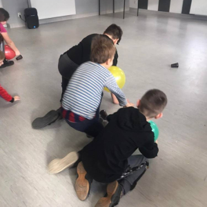 Grupa dzieci bawiących się na podłodze. 